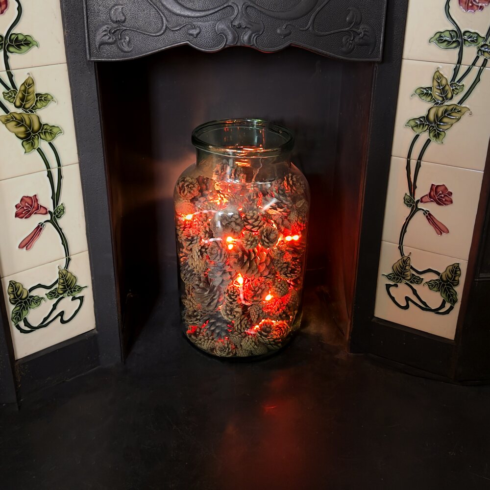 A jar of warm, fire-coloured LEDs glowing on a hearth, driven by the Fire String board.